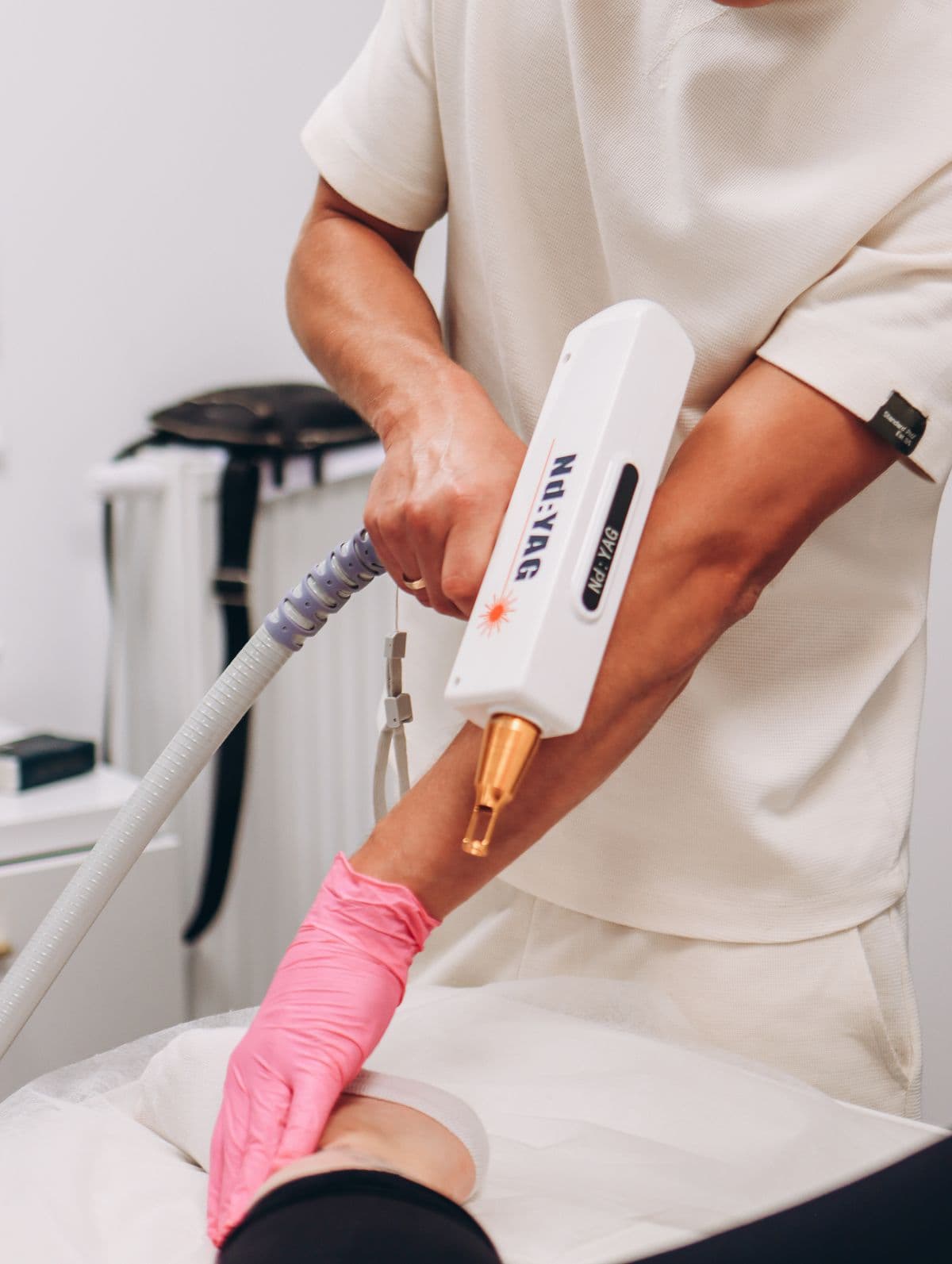 A laser hair removal treatment being performed on a client's arm